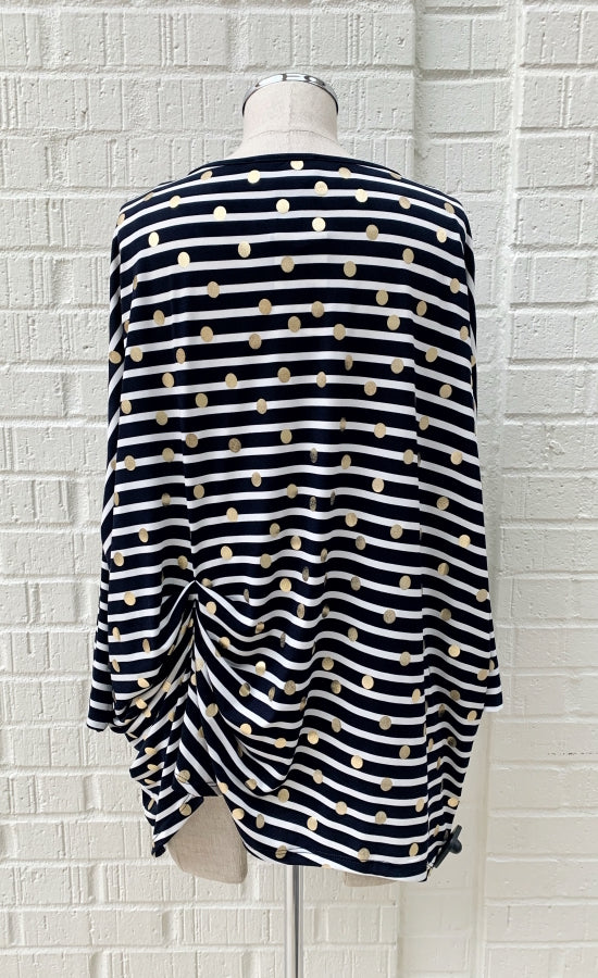 Back view of a mannequin wearing the Frank Lyman Navy & White Striped Knit Tunic. This striped tunic features gold dots all over it, 3/4 length dolman sleeves, and a gathering on the left side near the hip.