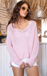 Load image into Gallery viewer, Front top half view of a woman wearing white shorts and the wooden ships maui v cotton sweater in pink conch. This top has extra long sleeves, a v-neck, and a loose knit.
