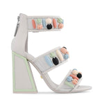 Load image into Gallery viewer, Outer view of the kat maconie cardi high-heel. This shoe is white with three straps. Each strap is decorated with pastel colored beads. The heel is geometric with pastel green outlining.
