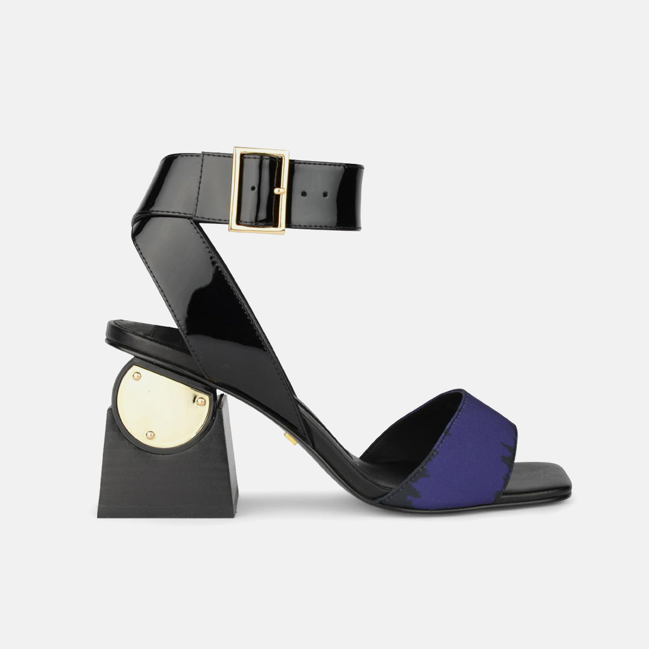 Outer side view of the kat maconie nyla sandal. This sandal has a black patent leather upper near the heel and a black patent leather ankle strap with a buckle. The upper near the square toe is blue and varnished. The heel is black with a gold circle.