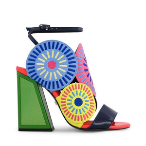 Outer side view of the kat maconie frida glitch high heel. This shoe features bright mutlicolored circles on the upper with a black strap over the toes and a black ankle strap. The high heel is green.