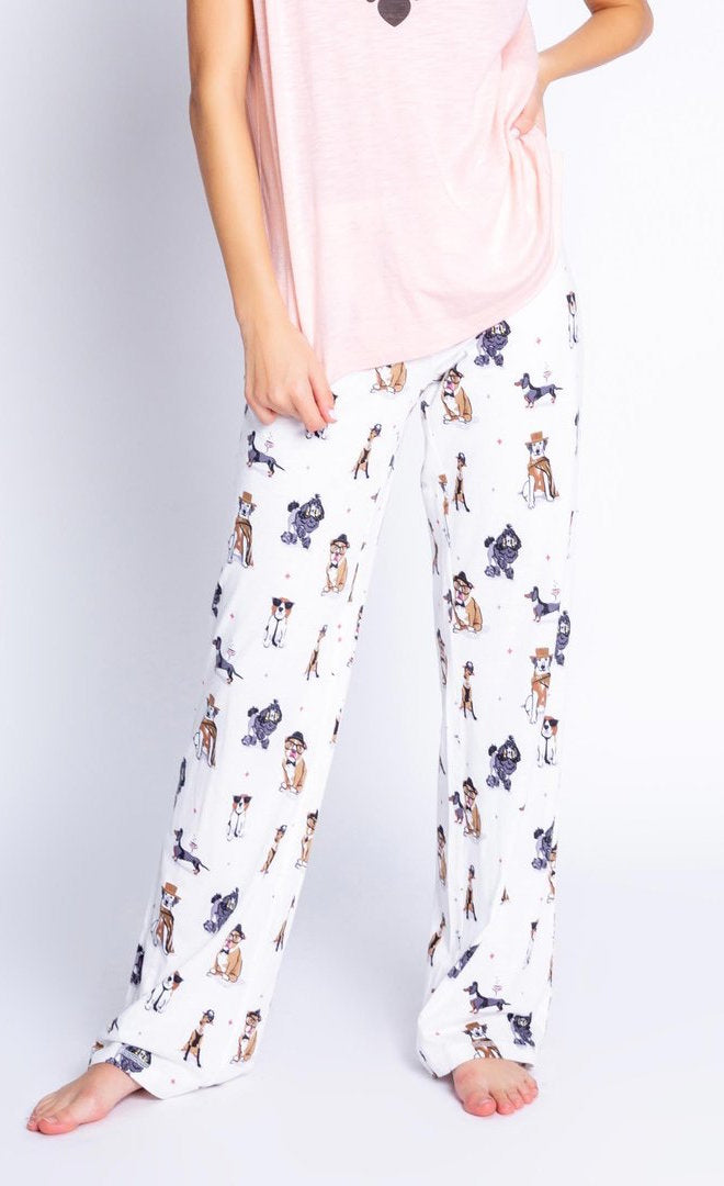 Front view of the bottom half of a woman wearing the PJ Salvage Love & Dogs pajama pant with a mix of hipster dogs printed on it.