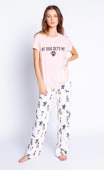 Load image into Gallery viewer, Front full body view of a woman wearing a pink tee from PJ salvage that says My Dog Gets Me. On the bottom the woman is wearing a PJ Salvage Love &amp; Dogs pajama pant with a mix of hipster dogs printed on it.
