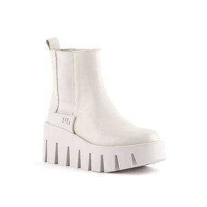 outer front side view of the united nude grip chelsea lo boots. These boots are white/light grey colored. The boots have elastic goring on the sides and a lug wedge platform sole.