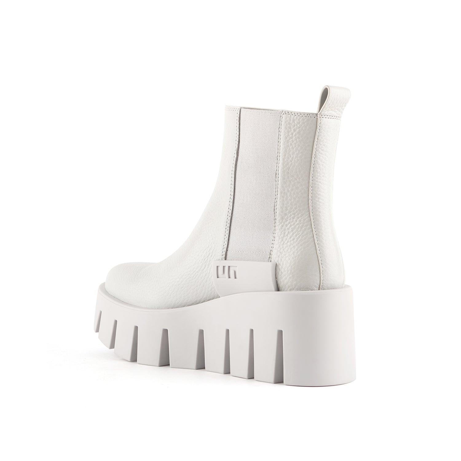 inner back side view of the united nude grip chelsea lo boots. These boots are white/light grey colored. The boots have elastic goring on the sides and a lug wedge platform sole.