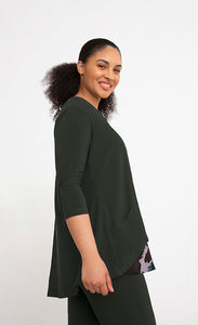 Right side top half view of a woman wearing the sympli nu whisper split back top. This top is in the color green/seaweed with a mineral print peeking out from the bottom. The top has 3/4 length sleeves and a round neck.